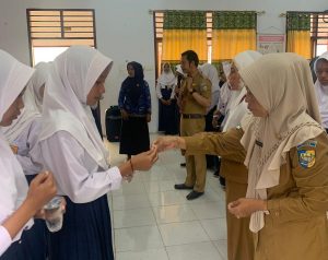 Kepala Puskesmas Bintauna Fitriani Ponongoa S.ST. M.Kes. saat memberikan tablet tambah darah kepada siswi SMP Negeri I Bintauna